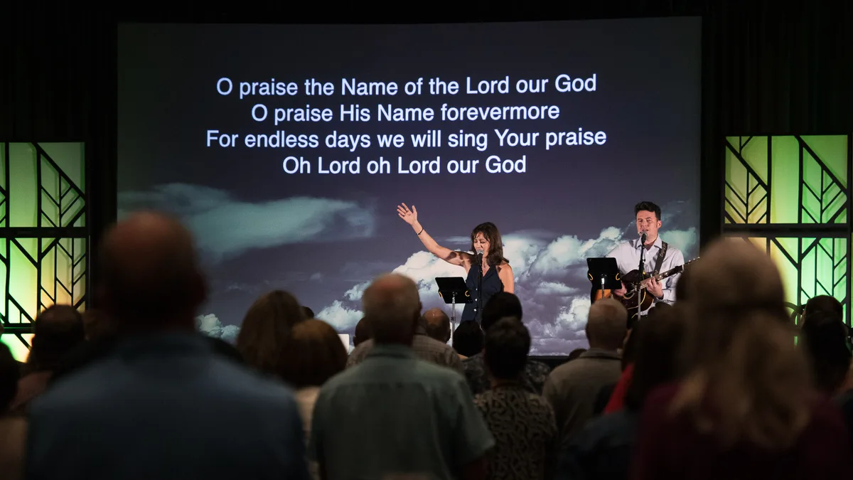 Worship at the Mission Leaders Conference, lyrics on screen above the congregation