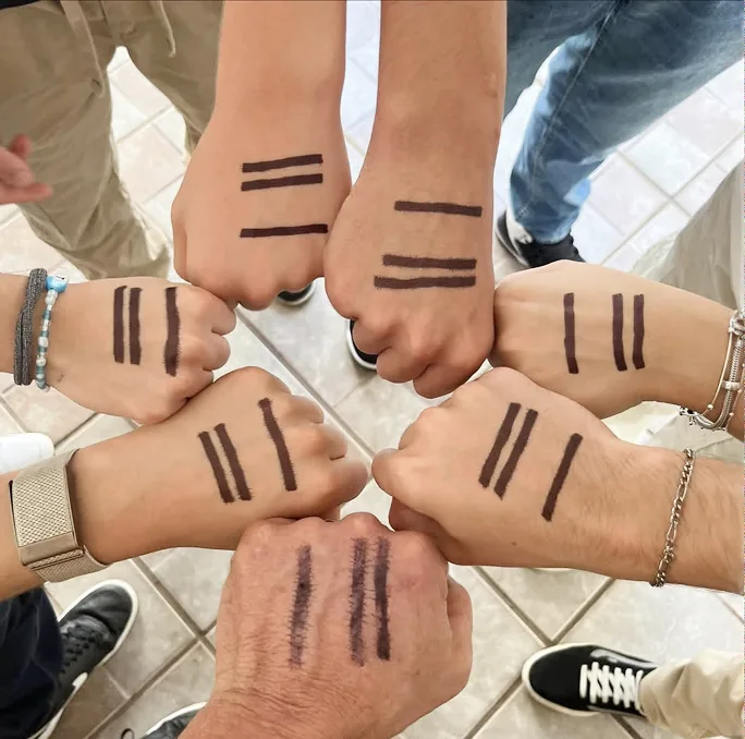 Hands arranged in a circle, each marked with the A Third of Us three-line symbol